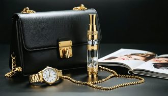 An opulent vaping device embellished with gold, alongside a designer handbag and luxury fashion items, conveying a blend of style and elegance.